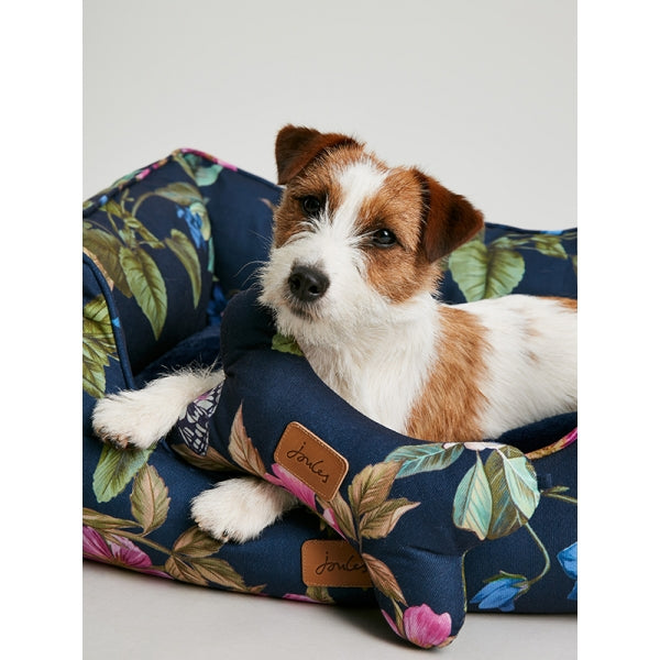 Close up of small dog laying in Joules Botanical Floral Box Bed with matching toy